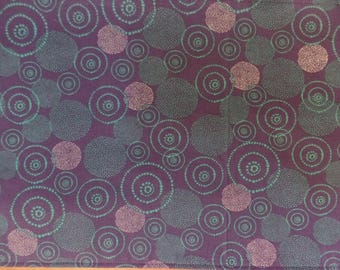 May include: Purple fabric with a repeating pattern of teal and white circles. The circles are of varying sizes and have a dotted pattern.