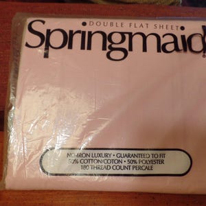 May include: A pink package with a white label that reads "Springmaid Double Flat Sheet" and "No-Iron Luxury - Guaranteed to Fit 50% Cotton/Coton 50% Polyester 180 Thread Count Percale".