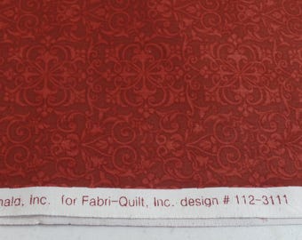 May include: Red fabric with a repeating pattern of intricate, swirling designs. The fabric has a label that reads "Ronald, Inc. for Fabri-Quilt, Inc. design # 112-3111".