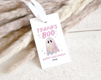 Pode incluir: Uma etiqueta de presente retangular branca com uma fita branca. A etiqueta apresenta o texto rosa "THANKS BOO" e "HAPPY HALLOWEEN" com uma linha "FROM:". Uma ilustração central mostra um pequeno fantasma iridescente com olhos pretos.