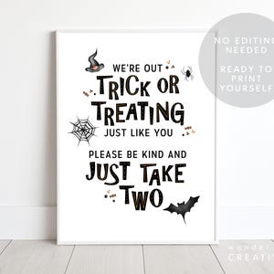 May include: A framed Halloween-themed print with black text on a white background. The text reads "We're out Trick or Treating just like you. Please be kind and just take two." Decorative elements include a witch hat, spider, spiderweb, candy, and bat.
