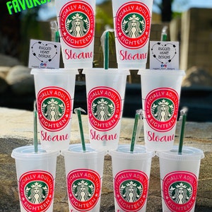 May include: Eight clear plastic cups with lids and straws. Each cup has a pink and white design that says "Officially Adulting" with a Starbucks logo and the name "Sloane" printed on the bottom.