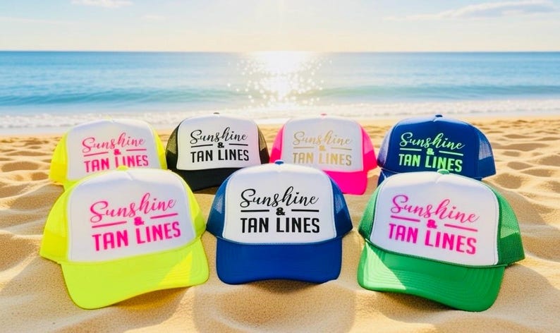 Puede incluir: Una colecci&oacute;n de seis gorras de camionero en varios colores, incluyendo amarillo ne&oacute;n, negro, rosa, azul y verde. Cada gorra presenta un panel frontal blanco con el texto Sunshine & TAN LINES impreso en una mezcla de letra cursiva y de molde.