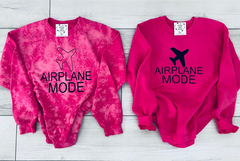 May include: Two pink sweatshirts with the text "Airplane Mode" and a small airplane graphic. One sweatshirt has a tie-dye effect.