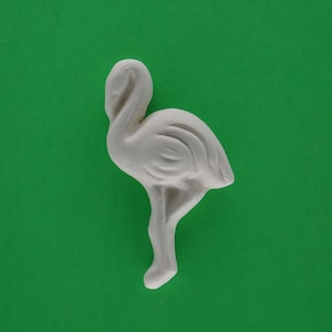 May include: White ceramic flamingo figurine with detailed feathers and a long neck. The figurine is standing on a green background.