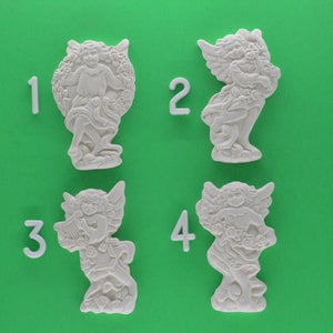 May include: Four white ceramic angel figurines with floral details. Each angel is holding a different object, such as a musical instrument or a wreath. The figurines are numbered 1 through 4.