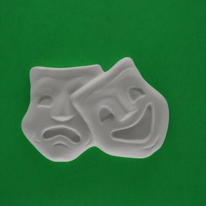 May include: Two white plaster masks, one with a smiling expression and the other with a frowning expression. The masks are joined together at the top.