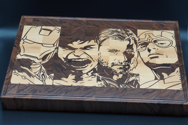 May include: A wooden cutting board with a checkered pattern, featuring laser-etched images of four popular superhero characters: Iron Man, Hulk, Thor, and Captain America.