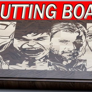 May include: A wooden cutting board with a checkered pattern and engraved images of four superheroes: Iron Man, Hulk, Thor, and Captain America. The board is made of dark wood with a light wood checkered pattern.