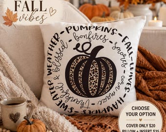 May include: A white square throw pillow cover featuring a central black pumpkin graphic with a leopard print pattern. The pumpkin is surrounded by a circular text design containing the words pumpkins, fall, leaves, hayrides, thankful, sweater, weather, and blessed.