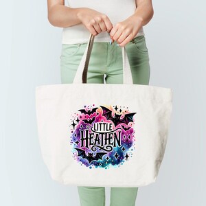 May include: A white tote bag with a colorful design featuring bats, stars, and the text "Little Heathen".