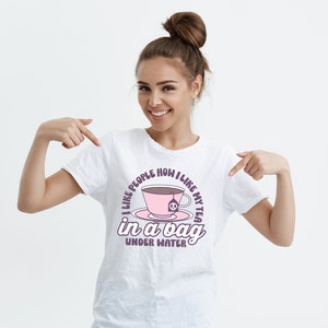 May include: White t-shirt with a pink teacup graphic and the text "I like people how I like my tea in a bag under water".