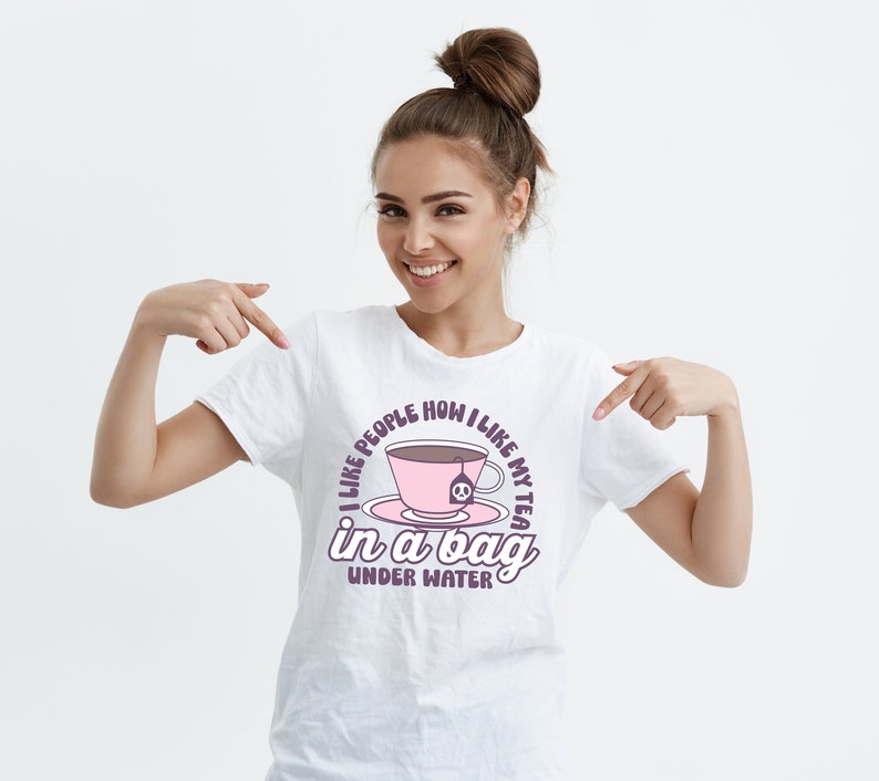 May include: White t-shirt with a pink teacup graphic and the text "I like people how I like my tea in a bag under water".