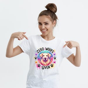 May include: White t-shirt with a colorful graphic of a dog's head and the text "Zero Woofs Given".