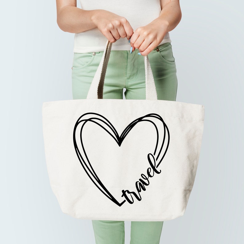K&ouml;nnte beinhalten: Eine wei&szlig;e Canvas-Tragetasche mit schwarzen Henkeln. Die Tasche hat eine schwarz-wei&szlig;e Grafik eines Herzens mit dem Wort "Reise" darin.