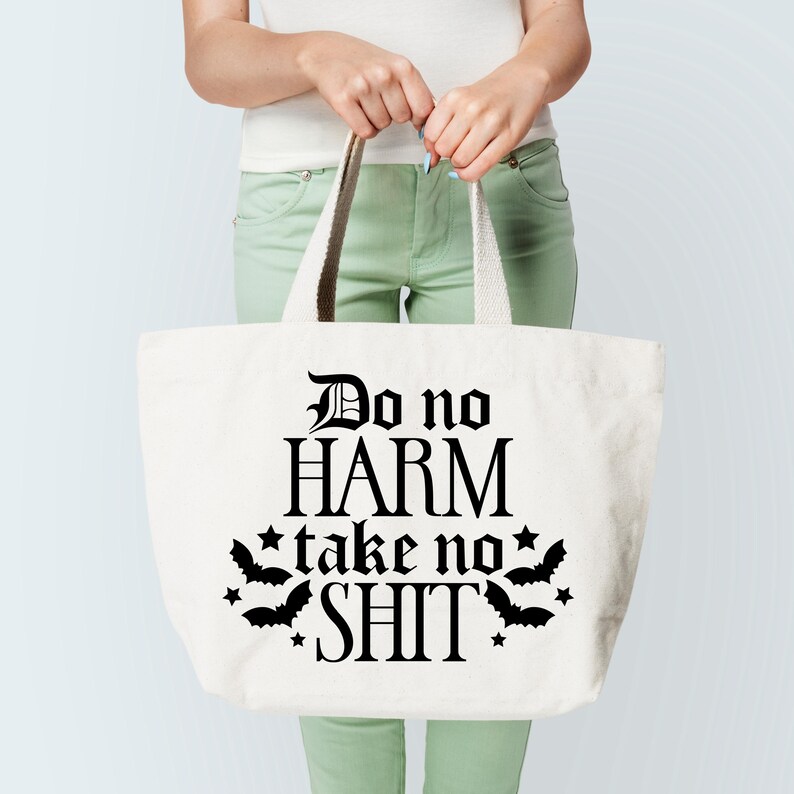 May include: White canvas tote bag with black text that reads "Do no HARM take no SHIT" with bat silhouettes and stars around the text.