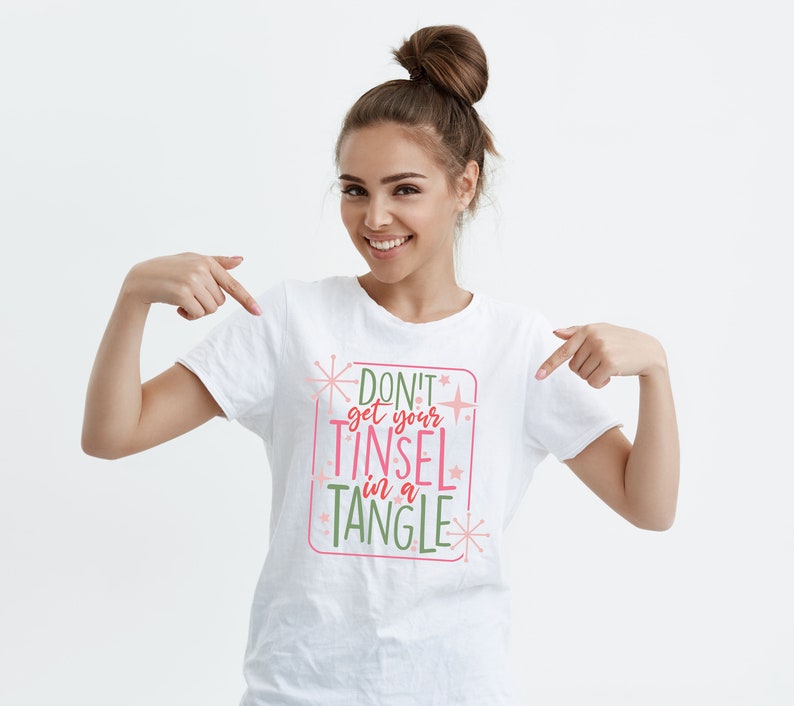 May include: White t-shirt with a pink and green graphic that says "Don't get your tinsel in a tangle".