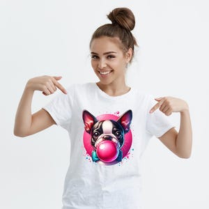Peut inclure: T-shirt blanc avec un motif repr&eacute;sentant un bouledogue fran&ccedil;ais noir et blanc portant un n&oelig;ud papillon bleu et soufflant une bulle rose. Le bouledogue est dans un cercle rose avec des &eacute;claboussures de peinture bleue et blanche.