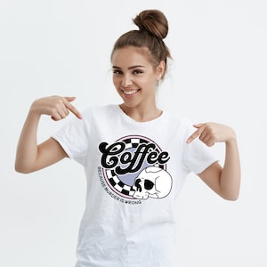 May include: White t-shirt with a black and white graphic design of a skull and the text "Coffee because murder is wrong".