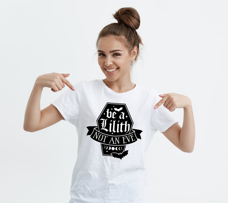 May include: A white t-shirt with a black graphic that says "be a Lilith not an Eve" with a crescent moon and stars design.