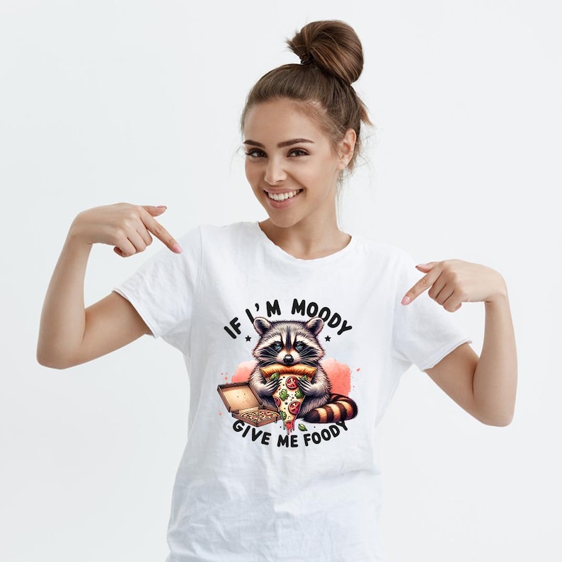 May include: White t-shirt with a graphic of a raccoon eating pizza and the text "If I'm Moody Give Me Foody".
