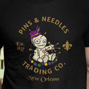 Mardi Gras Celebration Fat Tuesday Voodoo Doll Beads Pins And Needles Trading Co. Logo T-Shirt v2