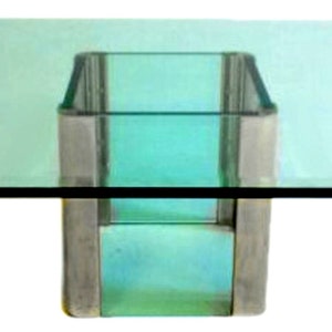 May include: A square glass coffee table with a clear glass top and a frosted glass base. The base is made of a metal frame.