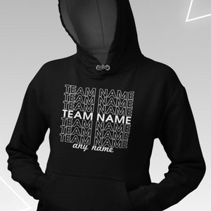 May include: Black hooded sweatshirt with a white graphic print that says "TEAM NAME" repeated multiple times. The text is stacked vertically and the last line says "any name".