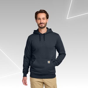 May include: A dark navy blue hooded sweatshirt featuring long sleeves, a front kangaroo pocket, and a small rectangular Carhartt brand patch sewn onto the lower right side of the pocket. The hoodie includes matching dark navy drawstrings.