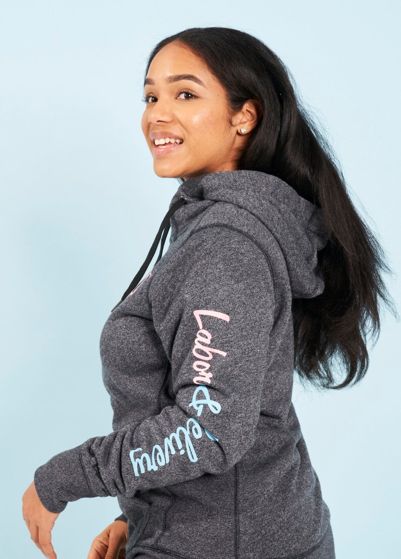 May include: A dark gray hooded sweatshirt with the words "Labor & Delivery" printed on the sleeve in pink and blue lettering.
