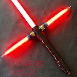 May include: A black and silver lightsaber with a red, glowing blade in a cross formation. The hilt has a textured grip and red accents. The text "ROGUE ARMS" is visible in red at the bottom of the image.