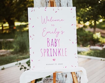 Op de afbeelding: Wit welkomstsbord met roze confetti en de tekst "Welkom bij Emily's Baby Sprinkle August 17, 2023".