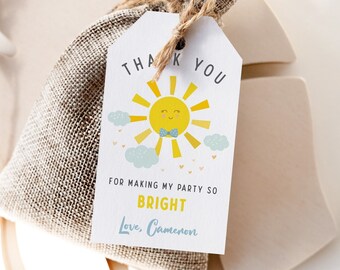 May include: A white thank you tag with a yellow sun with a blue bow tie and the text "Thank You for making my party so bright. Love, Cameron."