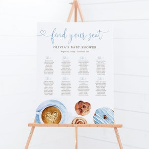 May include: A white seating chart with blue text for a baby shower. The chart is titled "Find Your Seat" and lists tables with guest names. The chart is decorated with watercolor illustrations of coffee, donuts, and pastries.