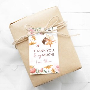 Pode incluir: Uma etiqueta de agradecimento branca com uma borda floral e uma ilustra&ccedil;&atilde;o de fada. O texto diz "Obrigado fada! Com amor, Olivia."
