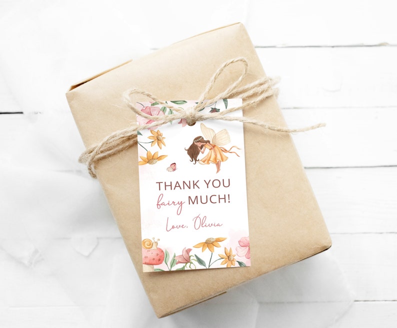 Pode incluir: Uma etiqueta de agradecimento branca com uma borda floral e uma ilustra&ccedil;&atilde;o de fada. O texto diz "Obrigado fada! Com amor, Olivia."