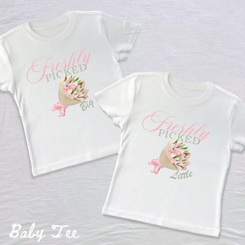 May include: Two white t-shirts with pink flowers and the text "Freshly Picked" on them. One shirt says "Big" and the other says "Little".