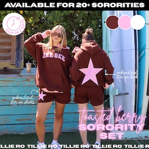 May include: A brown hooded sweatshirt and matching shorts set featuring a pink star pattern. The sweatshirt has the text DEE GEE on the front, while the back and the shorts feature an embroidered star. The set includes pink accents.