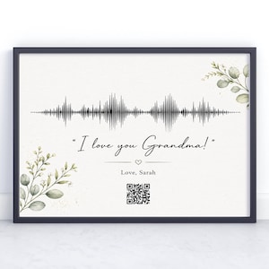 May include: Framed print with a black border, featuring a sound wave design and the text "I love you Grandma!" in elegant script. Includes a QR code and the name "Love, Sarah." Decorated with watercolor eucalyptus leaves.