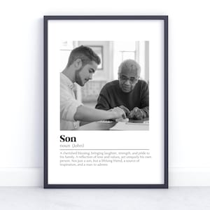 Könnte beinhalten: Schwarzweißfoto von zwei Personen, die an einem Tisch sitzen. Die jüngere Person schaut auf den Tisch, während die ältere Person in die Kamera schaut. Der Text unter dem Foto lautet: "Sohn Substantiv (Johannes) Ein geschätzter Segen, der Lachen, Stärke und Stolz in seine Familie bringt. Ein Spiegelbild von Liebe und Werten, aber auch einzigartig in seiner Art. Nicht nur ein Sohn, sondern ein Freund fürs Leben, eine Quelle der Inspiration und ein Mann, den man bewundert."
