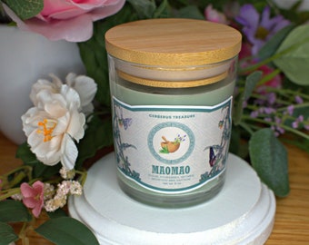 May include: A green glass candle jar with a wooden lid. The label reads "Cerberus Treasure" and "Maomiao" with a green and white illustration of a mortar and pestle with lavender flowers.