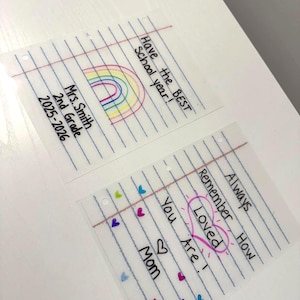 Puede incluir: Dos tarjetas transparentes estilo papel rayado con mensajes escritos a mano. Una tarjeta dice "Have the BEST School year!" con un arco&iacute;ris. La otra dice "Always Remember How Loved You Are!" con corazones y la palabra "Loved" en un coraz&oacute;n.