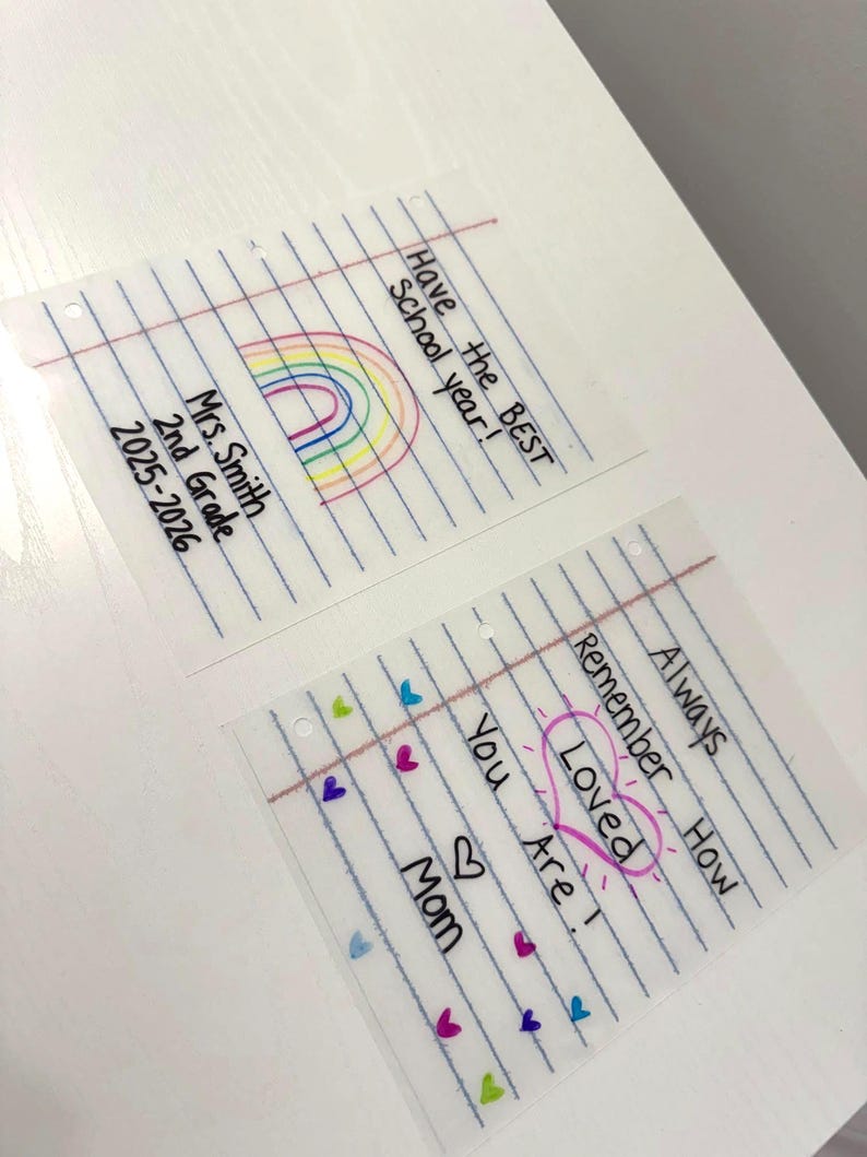 Puede incluir: Dos tarjetas transparentes estilo papel rayado con mensajes escritos a mano. Una tarjeta dice "Have the BEST School year!" con un arco&iacute;ris. La otra dice "Always Remember How Loved You Are!" con corazones y la palabra "Loved" en un coraz&oacute;n.