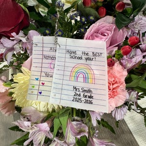 Puede incluir: Un vibrante ramo de flores, que incluye rosas, lirios y claveles, con una nota escrita a mano que dice "Have the BEST School year!" y "Mrs. Smith 2nd Grade 2025-2026". Las flores son en tonos de rosa, rojo, amarillo y morado.