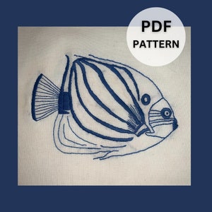 May include: A blue embroidered design of a fish on a white fabric background. The PDF pattern is available for download.