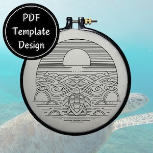 Könnte beinhalten: Ein schwarzer und weißer Stickrahmen mit einem Design einer Schildkröte, die im Meer schwimmt, mit einer untergehenden Sonne im Hintergrund. Das Design ist auf einem weißen Stoff.