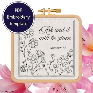 May include: A square wooden embroidery hoop containing white fabric with a black line art pattern of daisies and the text "Ask and it will be given Matthew 7:7". A circular badge in the top left corner displays the text "PDF Embroidery Template".