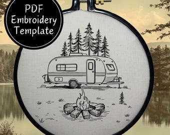 Op de afbeelding: Zwart-witte lijnkunst borduurontwerp van een camper die in een bos geparkeerd staat met een kampvuur ervoor. Het ontwerp is op een witte stoffen achtergrond.