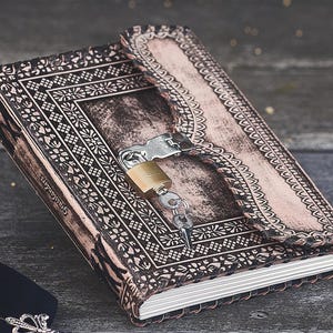 May include: A brown leather journal with a lock and key. The journal has an intricate design and is closed.