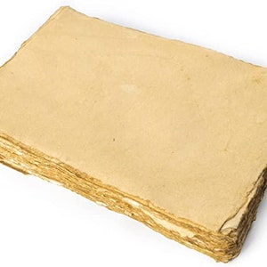 Puede incluir: Una pila rectangular de hojas de papel grueso hecho a mano de color marrón claro. El papel tiene una superficie fibrosa y texturizada con bordes irregulares y deshilachados que muestran la construcción en capas de las hojas apiladas.